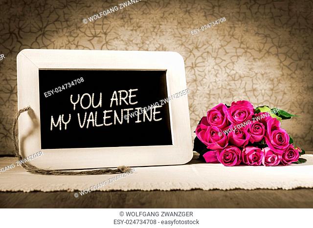 Image of a slate blackboard with message YOU ARE MY VALENTINE in sepia color and pink roses