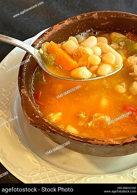 Eating beans with vegetables stew. Spain