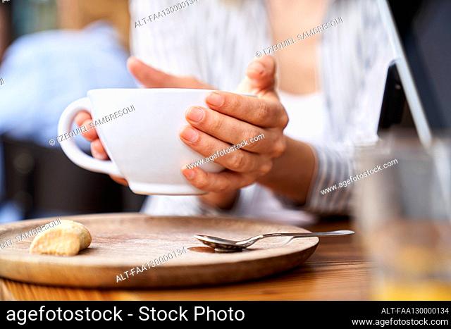 Close up photo of woman's hands holding a cup of coffee