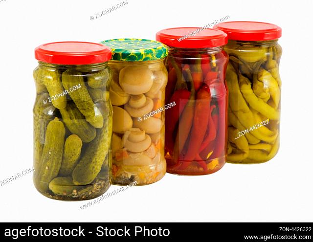 ecological natural food resource for winter mushroom peppers and cucumbers preserved in glass pots jars isolated on white background