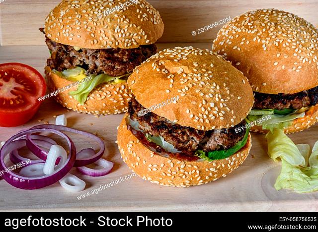 Three fresh burger lay on the board. Homemade fast food more tasty and healthy