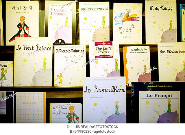 Shelves in a book shop with the book The Little Prince in different editions and languages