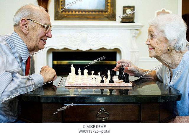 Elderly couple playing chess