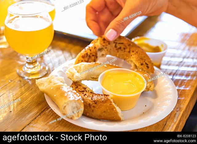 Woman enjoys warm pretzels and micro brew beer