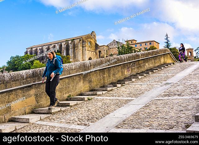 Woman with backpack pilgrimage walking on the Jail Bridge, Puente de la Cárcel, or Picudo Bridge, Puente Picudo. French Way, Way of St. James