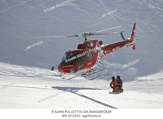 Rescue helicopter taking-off after the rescue of an injured skier on Leukerbad ski piste, Valais, Switzerland, Europe