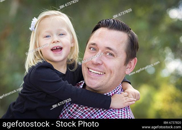 Adorable little baby girl having fun with daddy outdoors