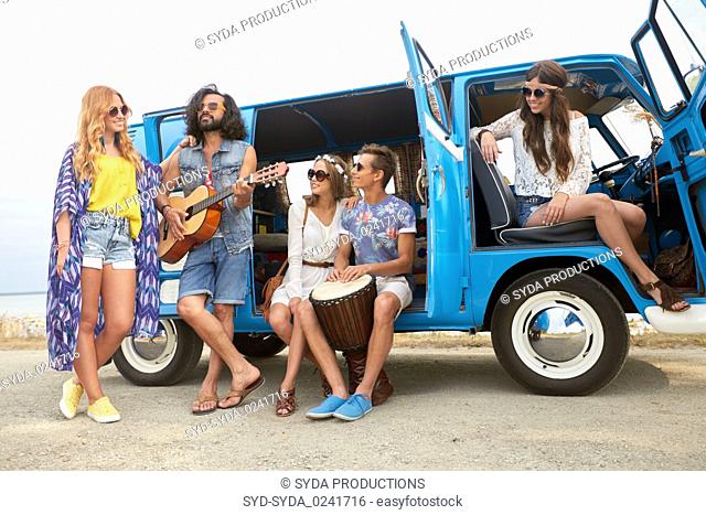happy hippie friends playing music in minivan