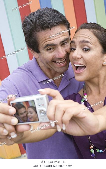 Couple taking a picture of themselves with digital camera