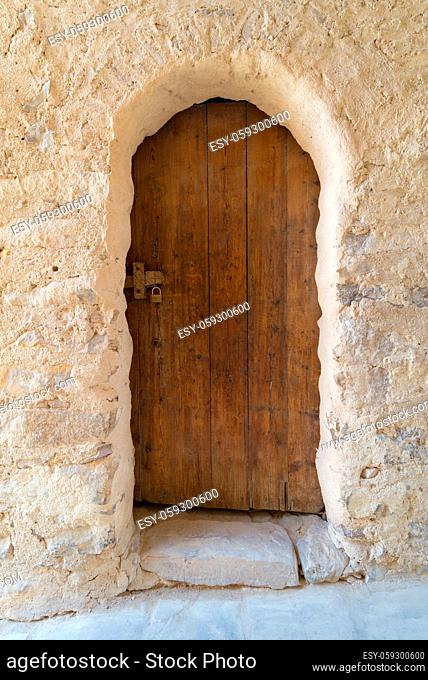 Ancient stone bricks wall and old wooden door at the Monastery of Saint Paul the Anchorite (aka Monastery of the Tigers), Egypt
