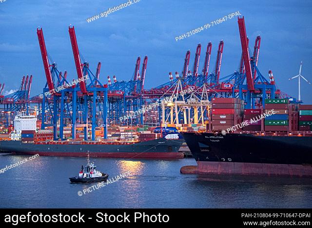 14 April 2021, Hamburg: Folded-up container gantry cranes are seen in the evening on the site of Hamburger Hafen und Logistik AG's (HHLA) Container Terminal...