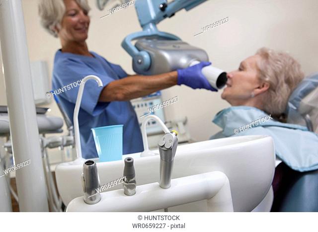 Female dentist taking X-Ray of her patient