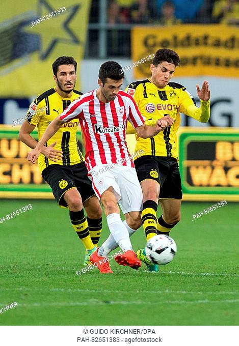 Dortmund's Marc Bartra (r) and Dortmund's Nuri Sahin (l) vie against Bilbao's Markel Susaeta (M) for the ball during the friendly soccer match between Borussia...