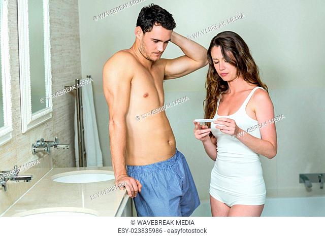 Worried couple checking results of pregnancy test
