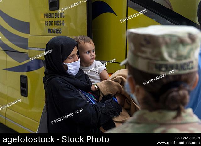 Refugees evacuated from Afghanistan arrive at Washington Dulles International Airport and make their way to a waiting bus in Chantilly, Virginia, Wednesday