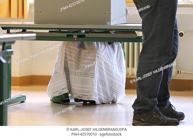 A woman wearing traditional Bavarian clothing casts her ballot in a polling station during the Bavarian State Parliamentary Election in Oberammergau, Germany
