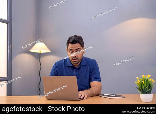 Male freelancer using laptop At Home Office