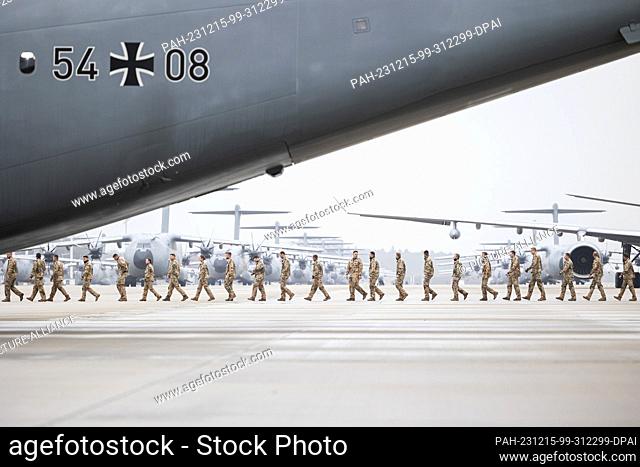 15 December 2023, Lower Saxony, Wunstorf: Soldiers walk across the grounds of Wunstorf Air Base after landing. Soldiers from the German contingent of the UN...