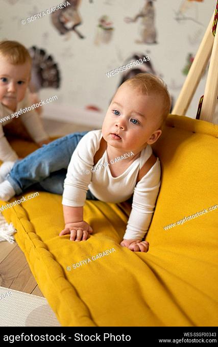Twin babies playing on couch at home