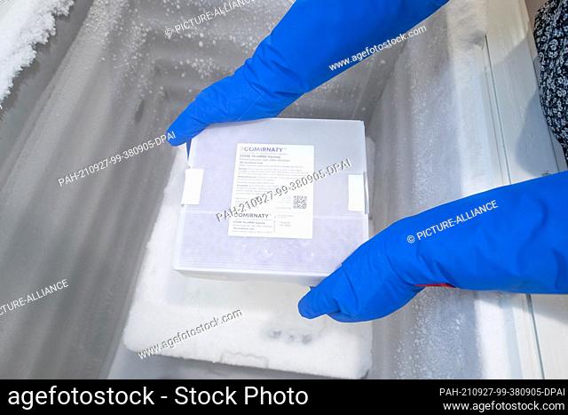 27 September 2021, Lower Saxony, Osnabrück: A frozen package with the vaccine ""Comirnaty"" from the manufacturer Biontech/Pfizer is lifted out of a freezer in...