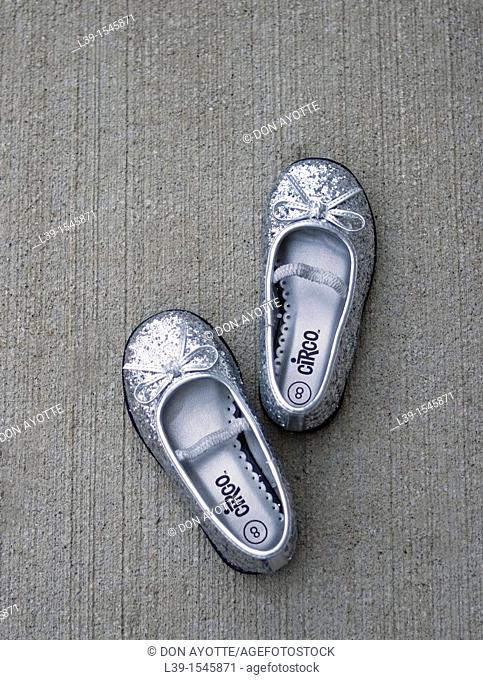 shoes placed by a child on cement