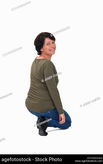 rear view of a woman crouching and looking at camera on white background