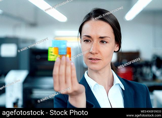 Businesswoman holding puzzle cube in industry