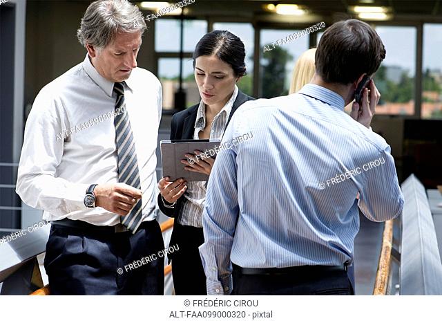 Businesswoman showing colleague digital tablet