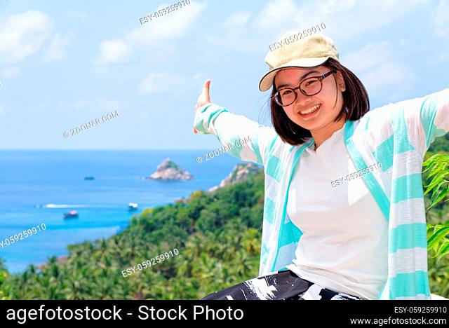 Women tourists extend the arms happily at high viewpoint to see the beautiful nature landscape of the sea and island on top of the Koh Tao island is a famous...