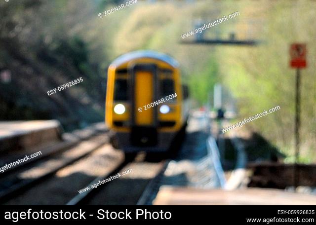 blurred image of a typical suburban pacer train arriving in a small railway station