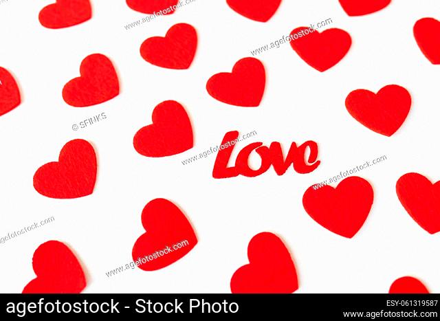 The background which consists of red hearts, the inscription love in the middle of the hearts. Love concept, greeting card for valentine's day