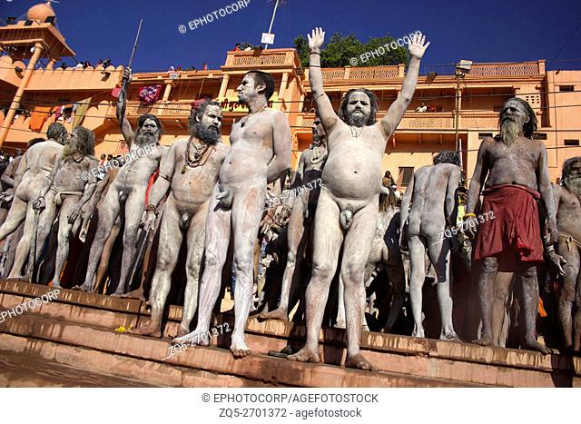 Naked Naga sadhus covered in ash standing on Shipra river bank for Shahi Snaan (Royal Holy Dip) Kumbh Mela 2016. Ujjain, Madhya Pradesh, India