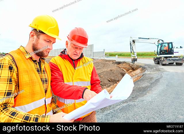 Bauarbeiter Team bei der Bauplanung mit Grundriss auf der Baustelle im Straßenbau