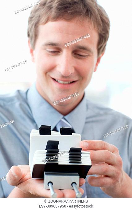 Caucasian businessman consulting a business card holder