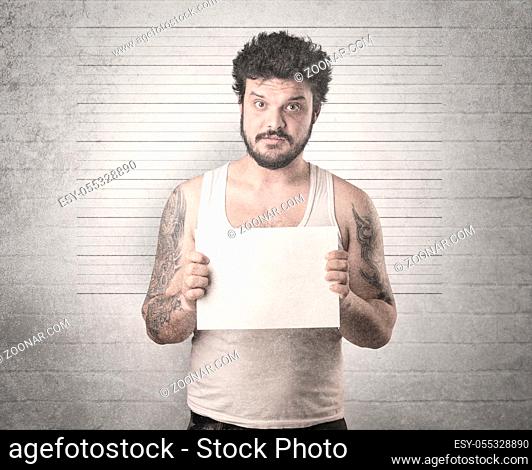 Gangster in front of a wall with table on his hand