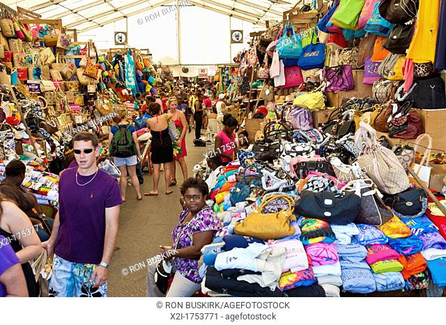 Men and women tourists shop in the crowded Straw Market for gifts and souvenirs in Nassau, Bahamas