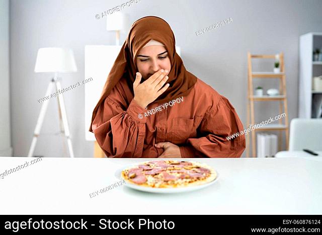 Woman Suffering From Stomach Pain While Having Pizza