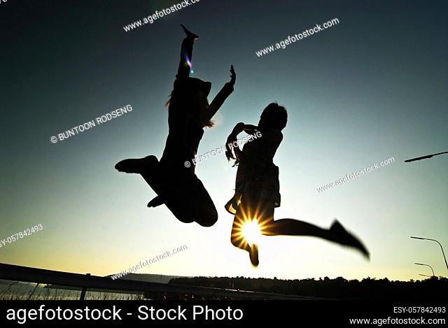 Silhouette happy woman jumping against beautiful in sunset. Freedom, enjoyment concept