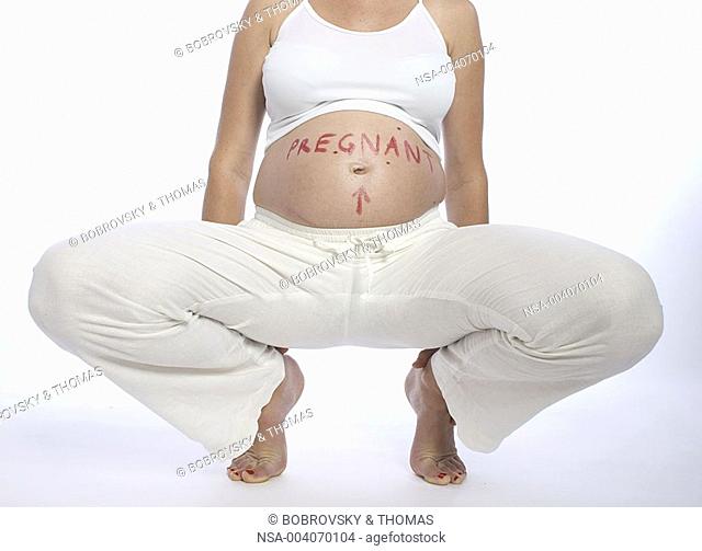 pregnant woman, 7th month, 'pregnant' written on belly