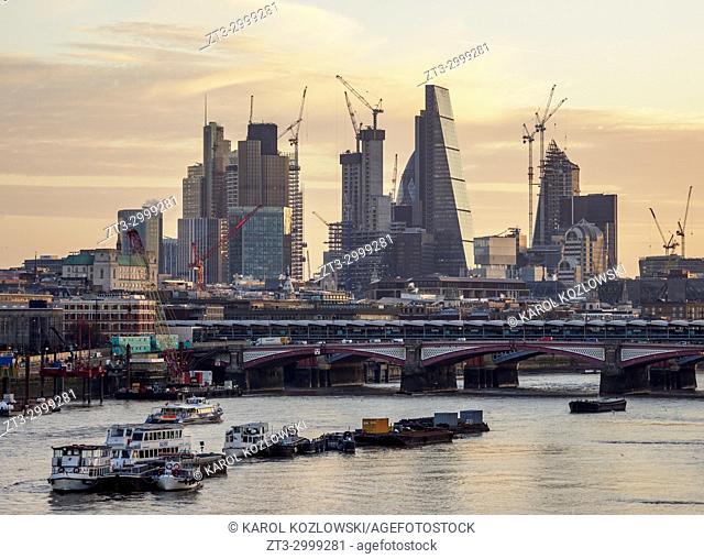 View over River Thames towards City of London at sunrise, London, England, United Kingdom