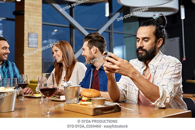 man messaging on smartphone at restaurant