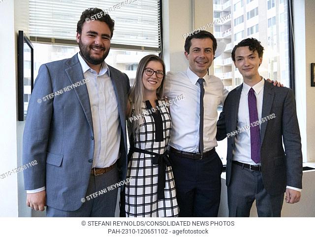 Mayor Pete Buttigieg takes a photo with Harry Applestein, Rebekah Macarthur, and Matt Landini at a communal parlor meeting at the offices of Bluelight...