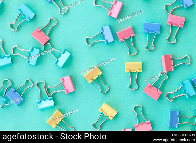 Bunte Papierklammern in Pastellfarben als flatlay Hintergrund