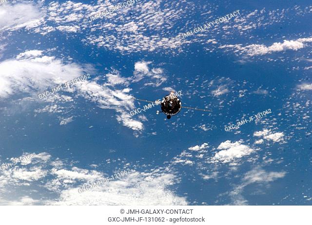 Backdropped by a blue and white Earth, an unpiloted Progress supply vehicle approaches the International Space Station (ISS)