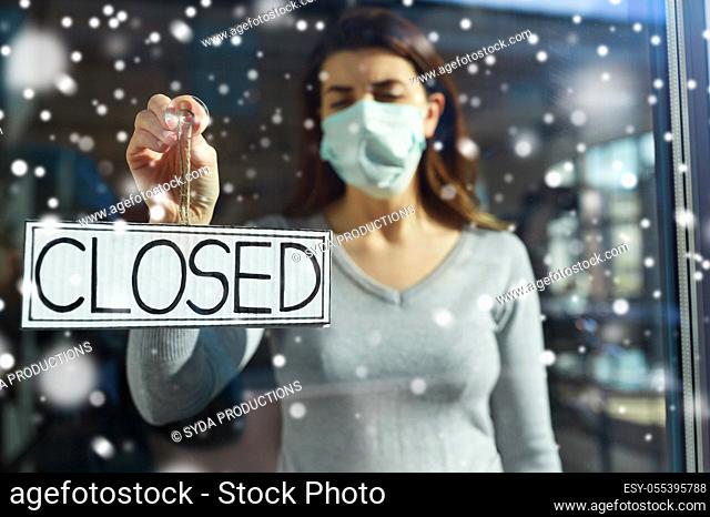 woman in mask hanging banner closed on door
