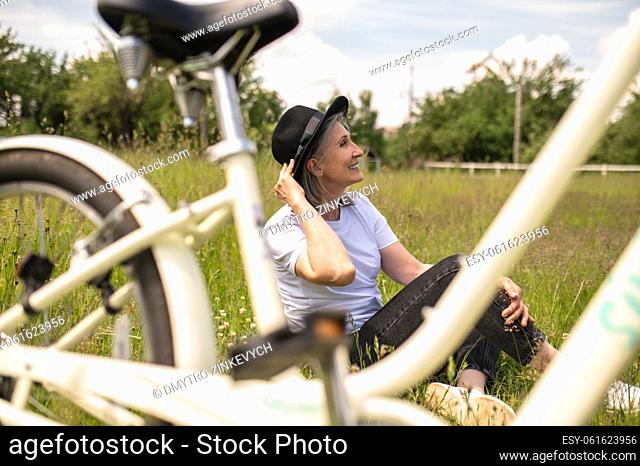 Good moments. A happy woman with a black hat enjoying and having fun in the countryside