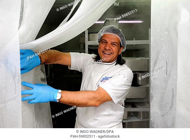 After a hot day Italian ice-cream maker Leonardo Caprarese looks out of his ice cream shop in Stuhr-Heiligenrode, Germany, 6 July 2015
