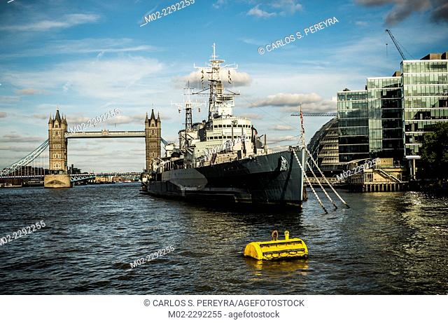 H.M.S. Belfast moored on the River Thames in London, England with Tower Bridge in the background