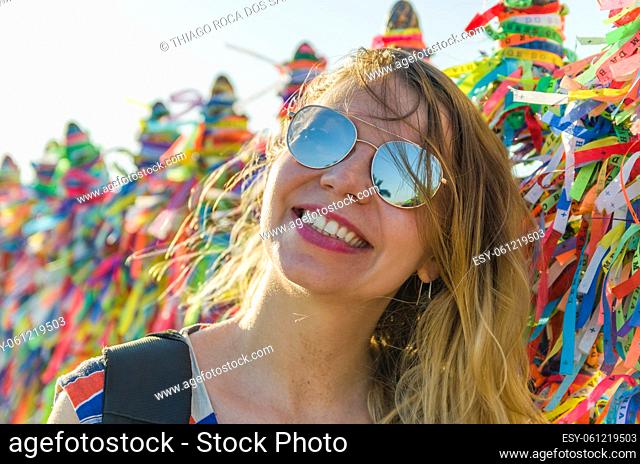 Girl in front of the grid with colored ribbons of Bonfim church in Salvador Bahia Brazil