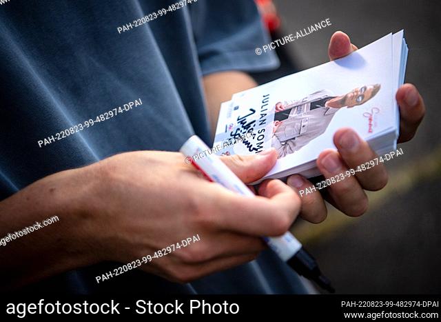 20 August 2022, Schleswig-Holstein, Hasenmoor: Julian Sommer signs autograph cards. Ballermann songs have hit the charts this summer